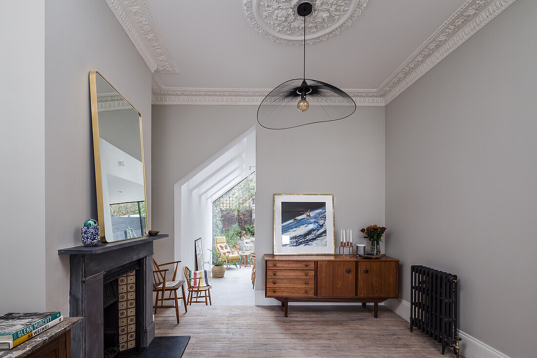 Fireplace and wooden furniture in room with light grey walls and stucco work