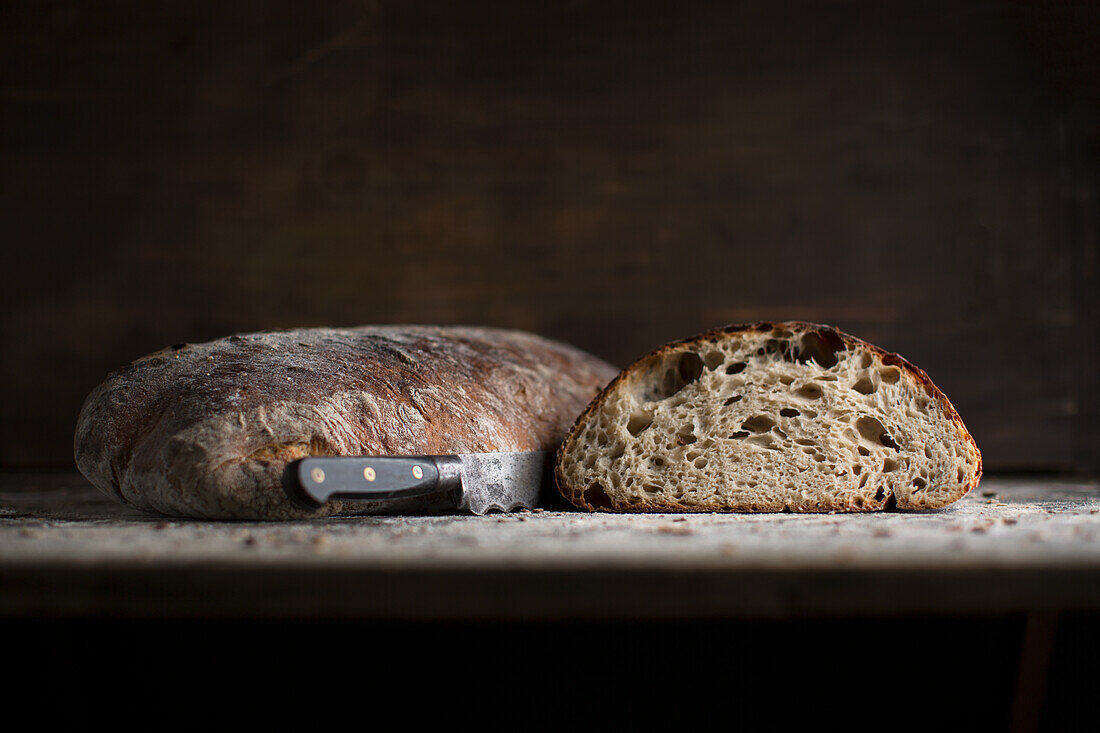 Rustic bread, whole and half with knife