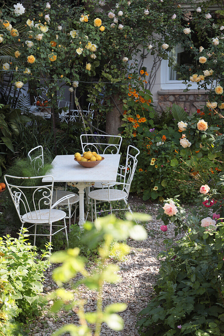 A seating area with decorative lemons in a rose garden