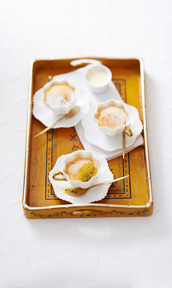 Passionsfrucht-Pudding serviert in Teetassen auf Tablett