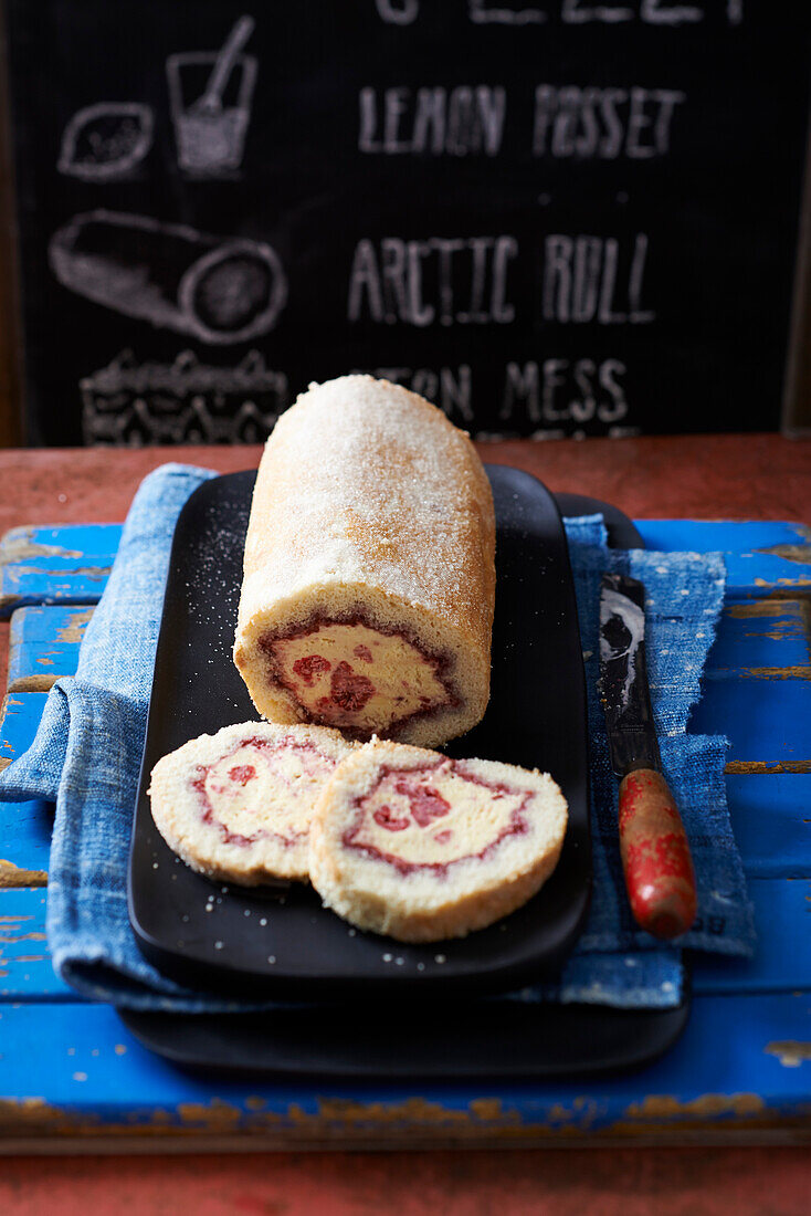 Biskuitrolle mit Schlagsahne und Himbeeren