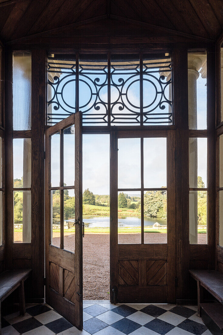 Alte Eingangshalle mit Holzdetails und Schachbrettfliesen in einem Landhaus