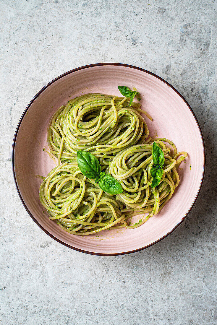 Dairy Free Pesto on spaghetti in a pink bowl