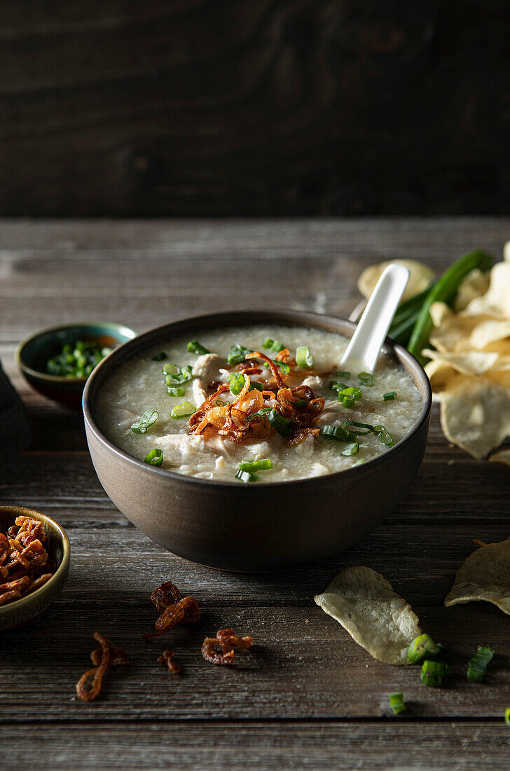 Chicken Jook (Asien) auf rustikalem Holztisch