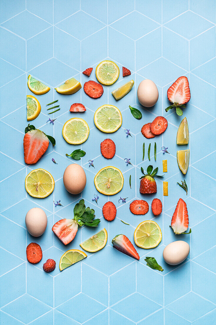 Komposition aus Zitronen- und Erdbeerscheiben und Eiern auf blauem geometrischem Untergrund