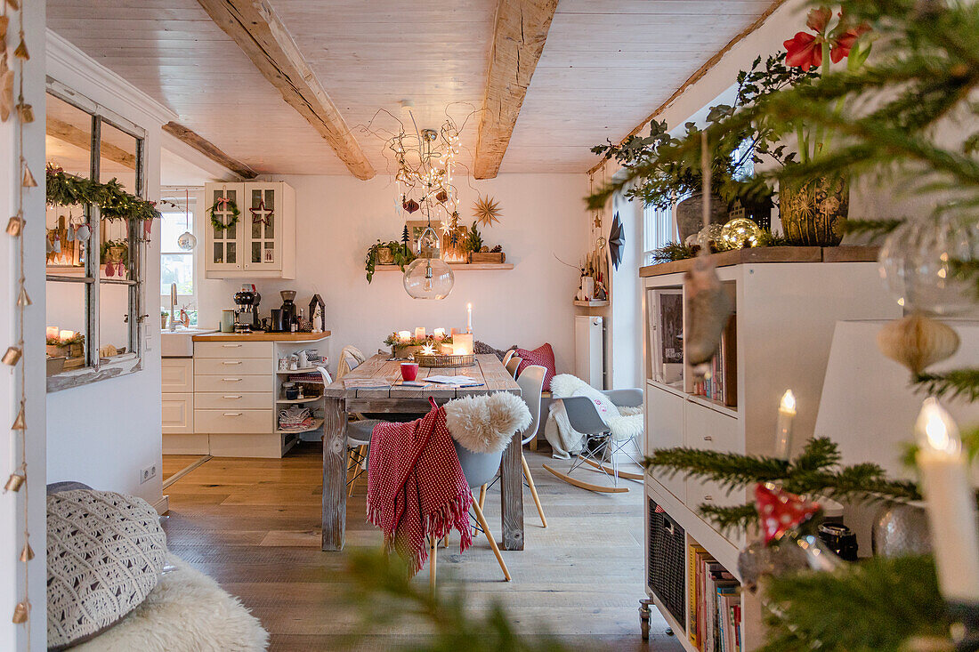 Weihnachtlich dekorierter Wohnraum mit geschmücktem Tannenbaum im Vordergrund