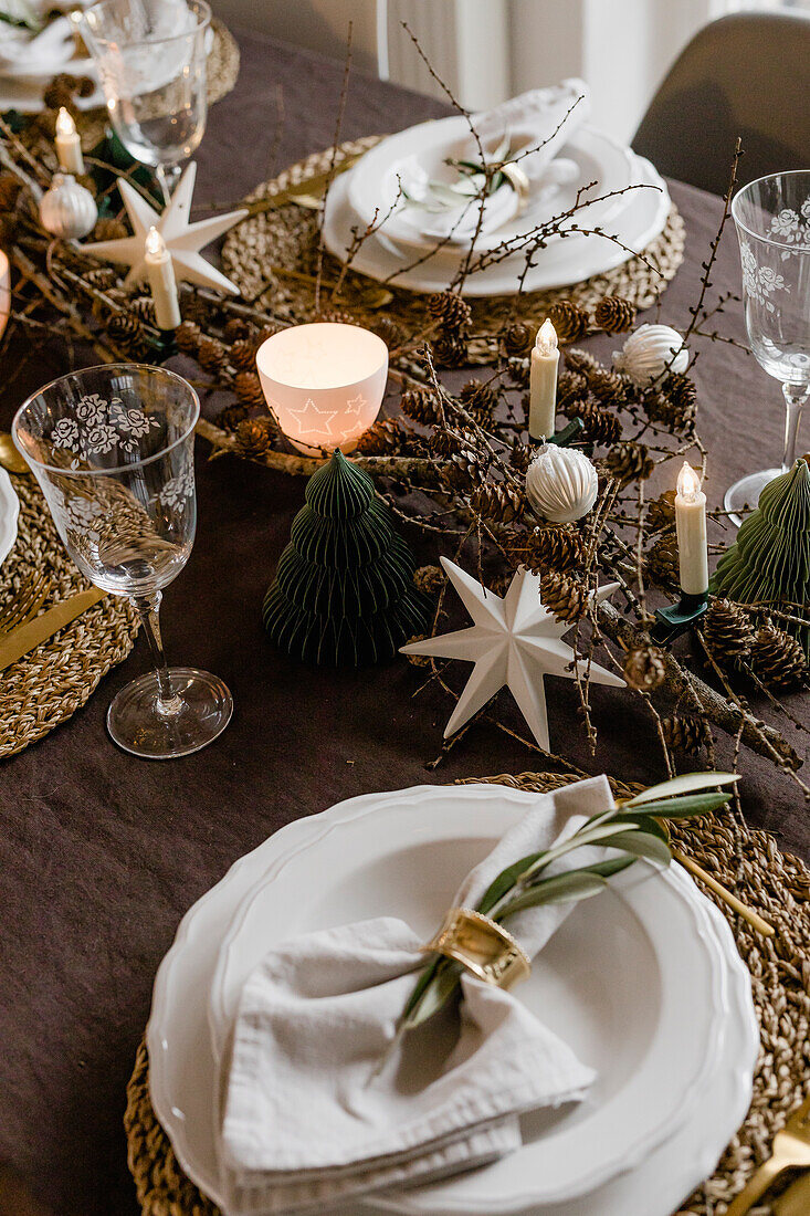 Weihnachtlich gedeckter Tisch mit Tischset aus Bast und weißen Tellern