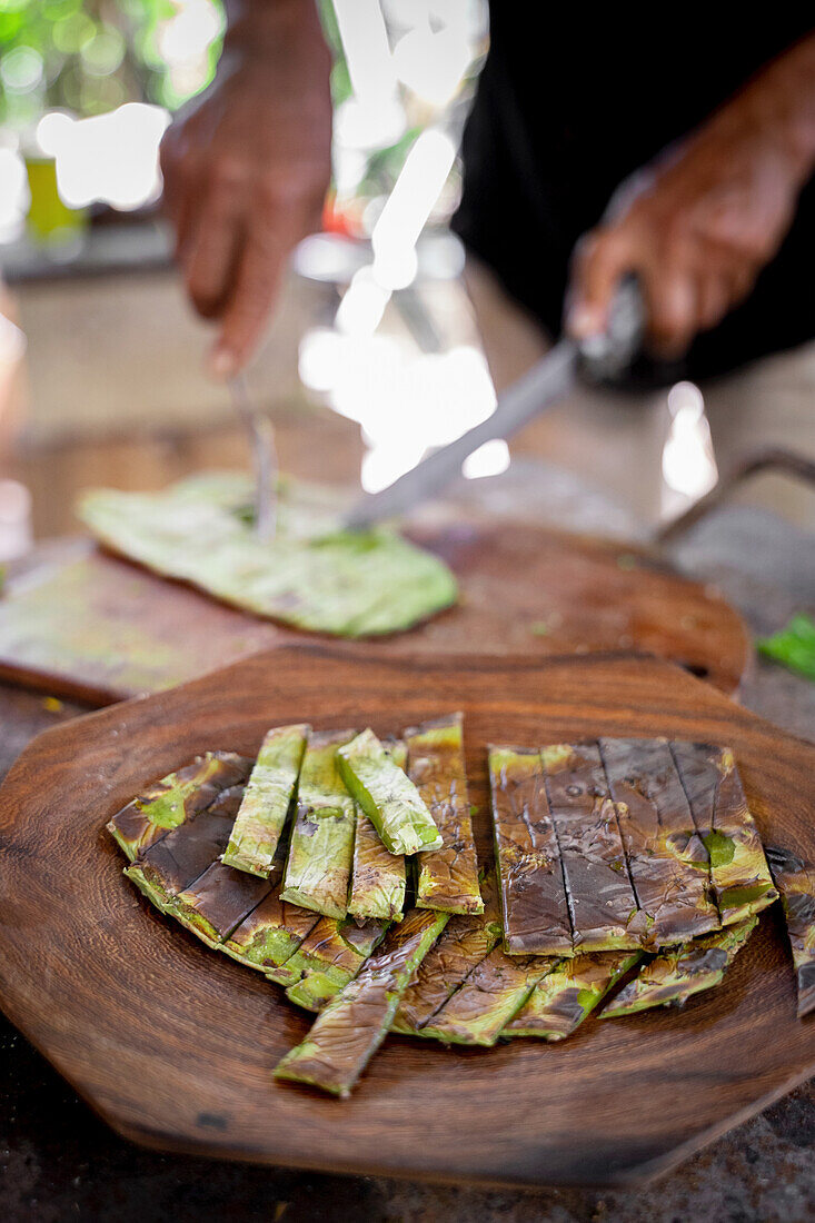 Slices of appetizing grilled green cactus leaves served on wooden plate