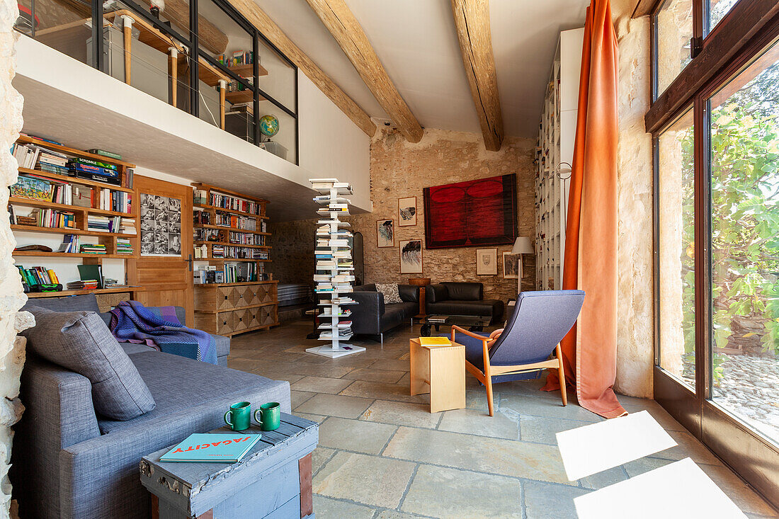 Open living room with wall of shelves, mezzanine above