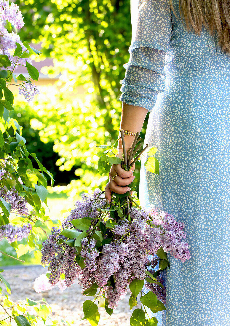 Woman holding bouquet of lilacs