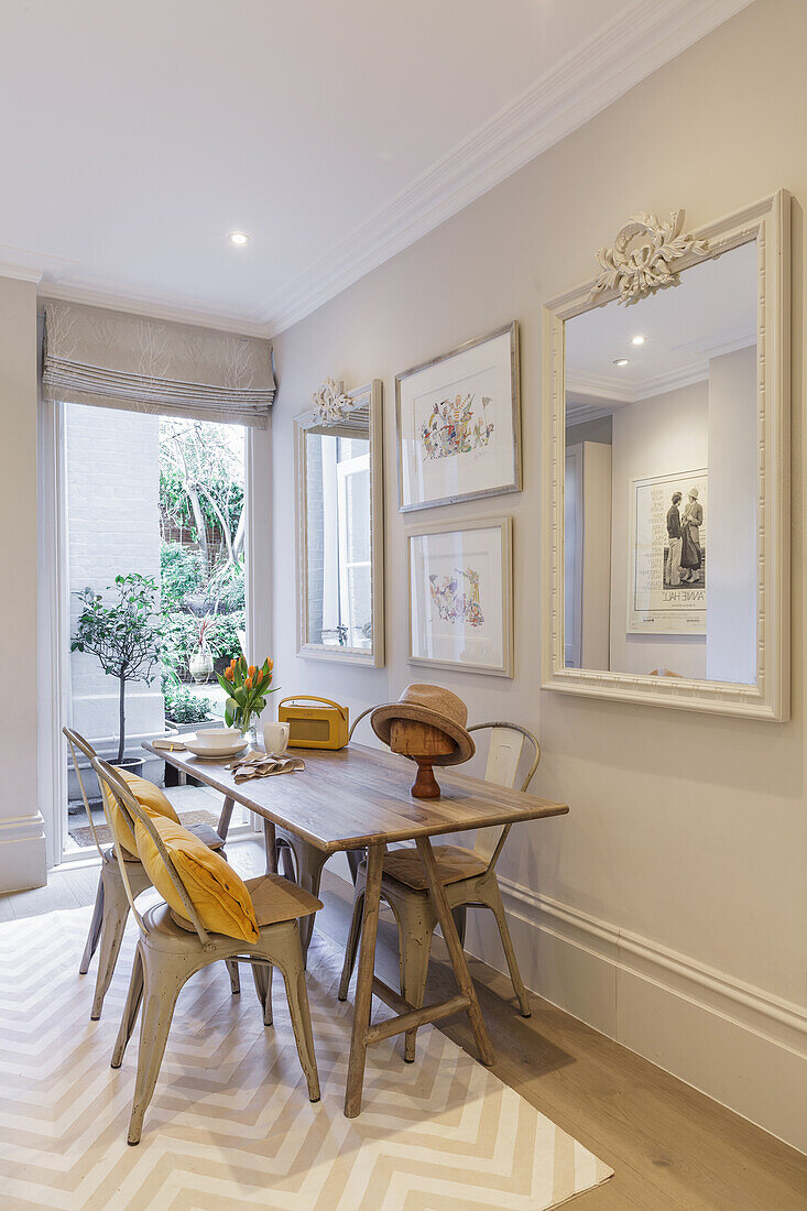 Wooden dining table with vintage metal chairs in a bright room