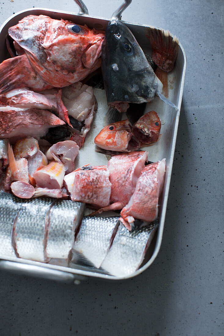 Rohe Fischteile im Metallbehälter