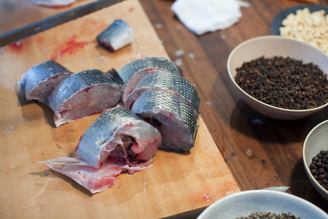 Frischer Fisch in Stücke geschnitten auf Holzschneidebrett