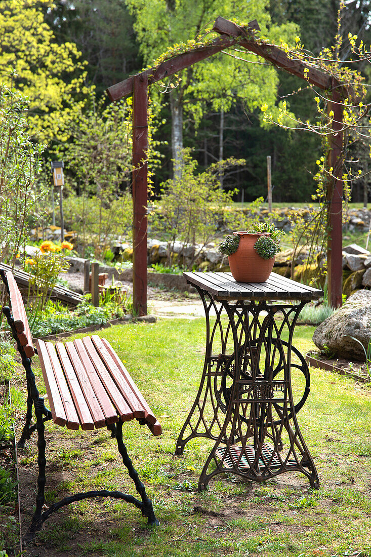 Inviting seating area with table made from old sewing machine in a garden