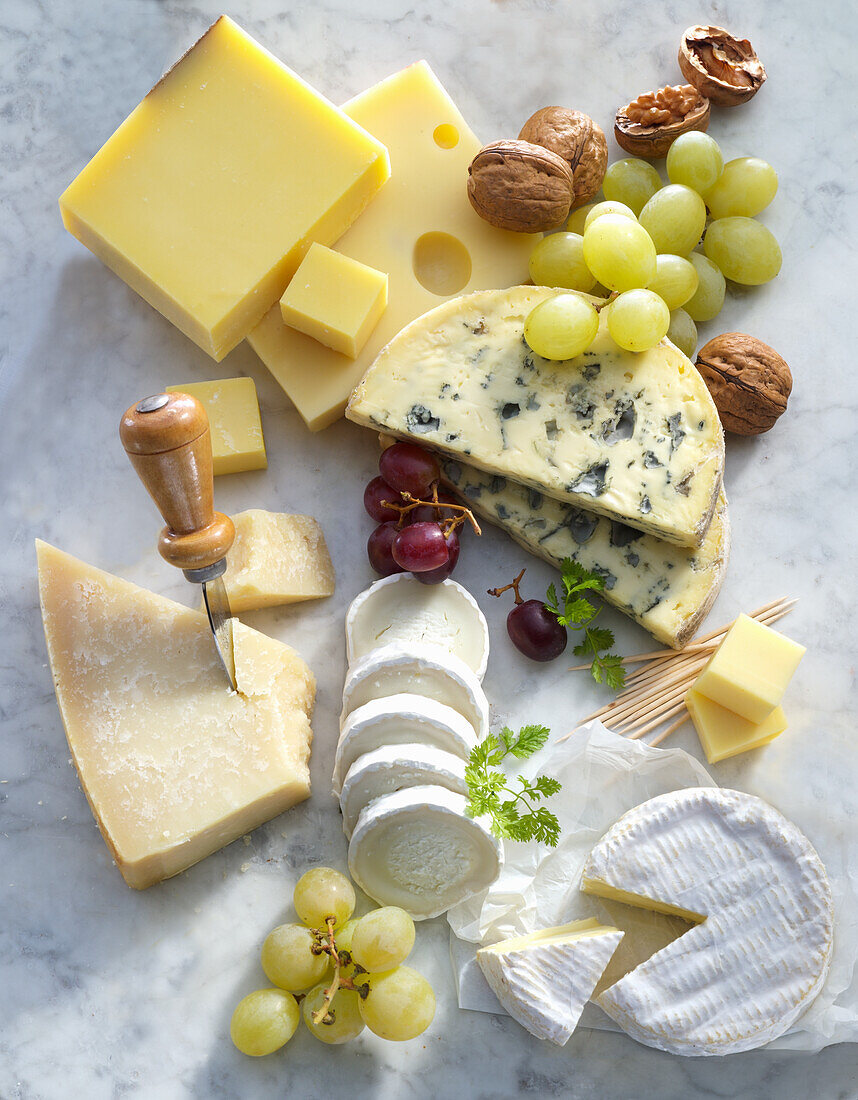 A cheese platter with grapes and walnuts