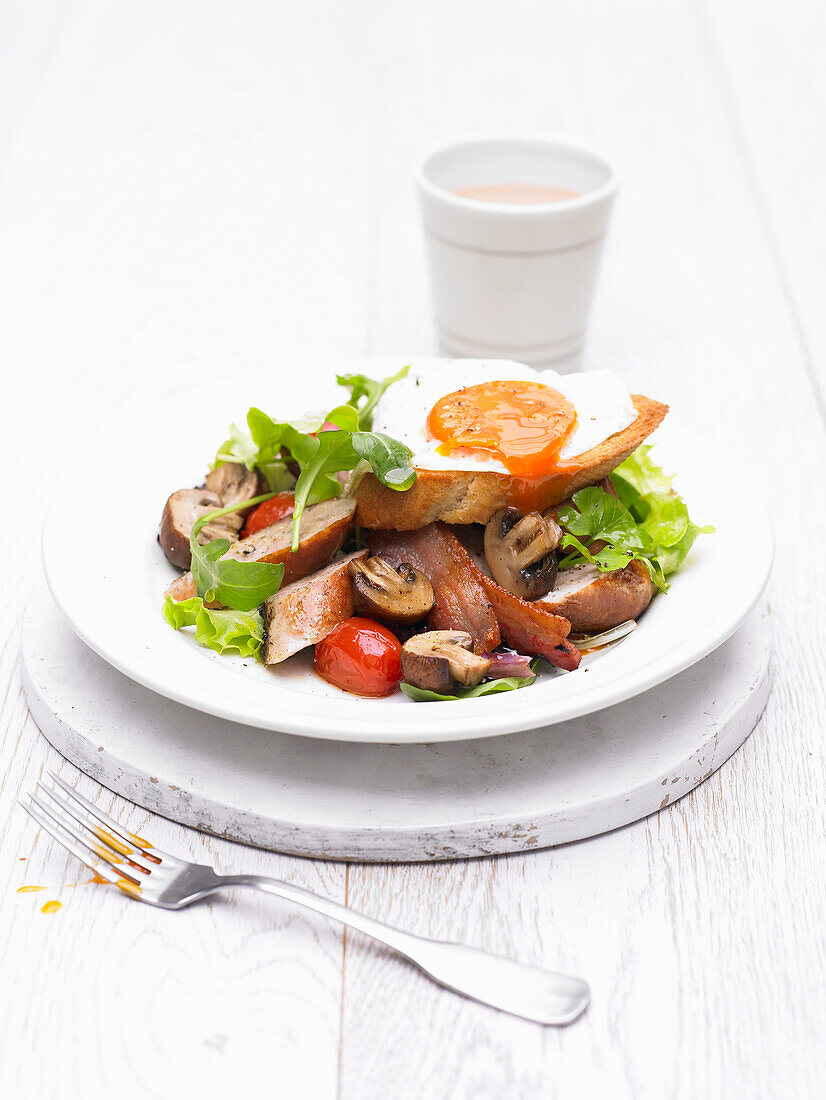 English salad with sausages, mushrooms, bread, and fried egg