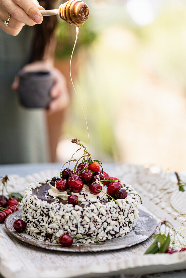 Chocolate cake with white chocolate shavings, cream and cherries
