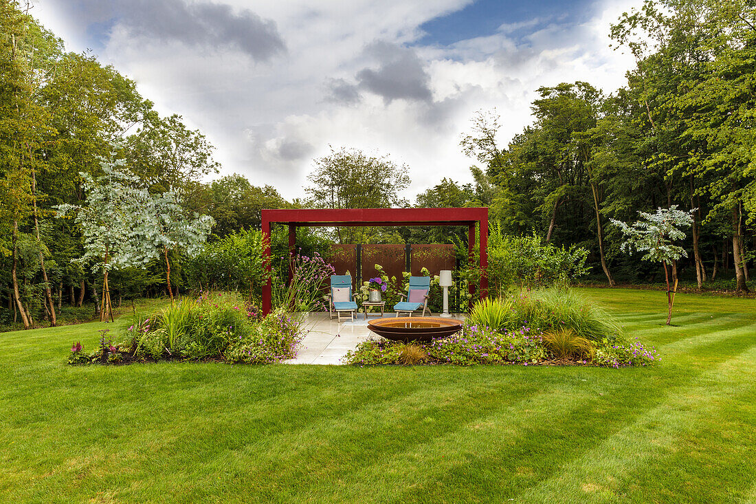Sitzplatz auf Terrasse in luxuriösem Garten mit gestreiftem Rasen