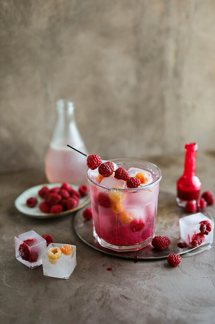 Lemonade with raspberry ice cubes and raspberry skewers