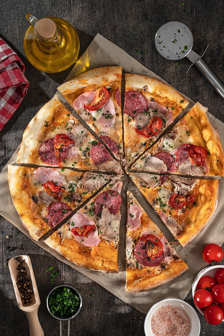 Pizza mit Salami, Schinken und Tomaten