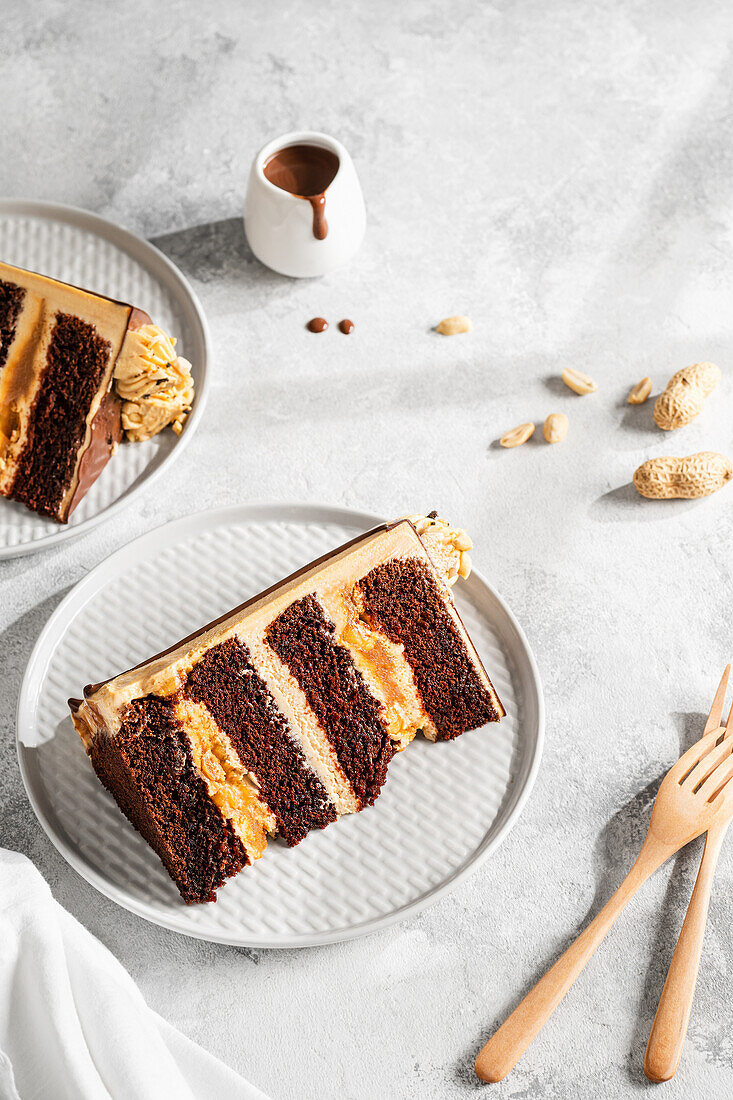 Ein Stück Schoko-Karamell-Torte mit Erdnüssen (Snickers Cake)