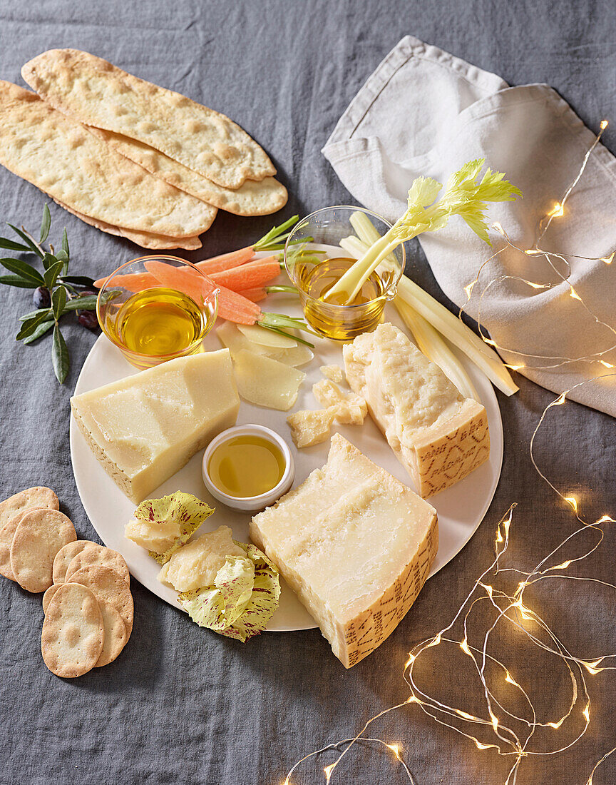 Käseplatte mit Grana Padano, Olivenöl und Gemüse