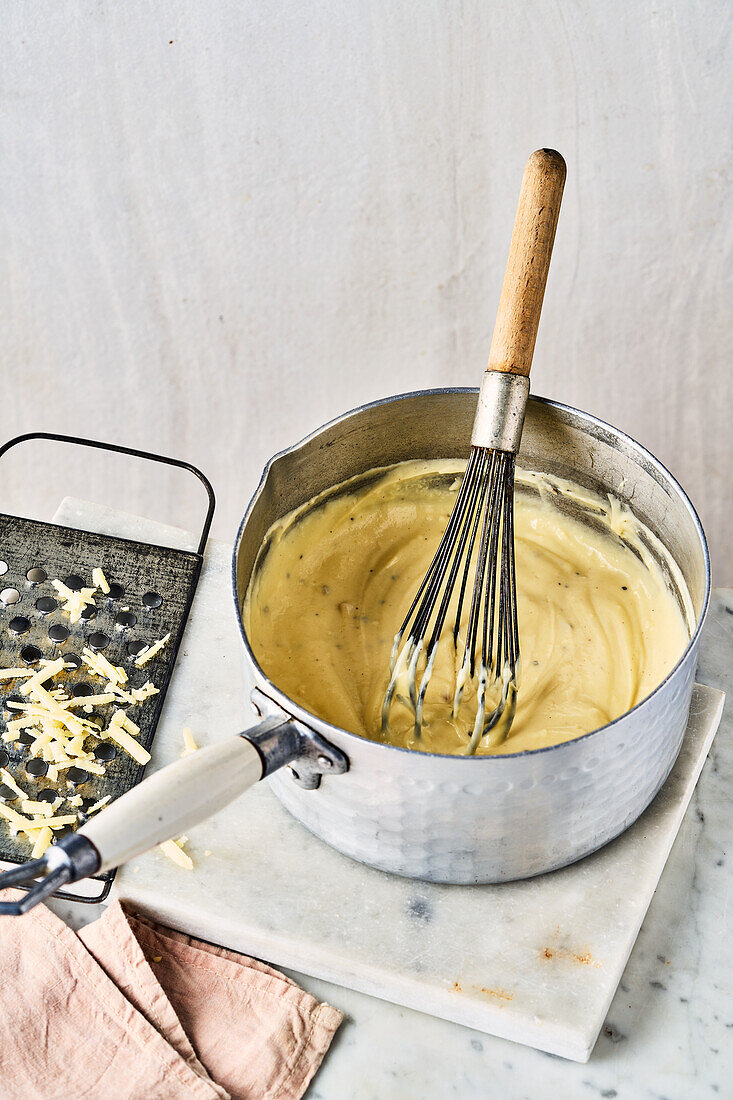 Cheese sauce with whisk in a saucepan
