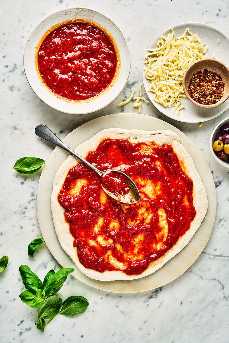Pizza dough spread with pizza sauce