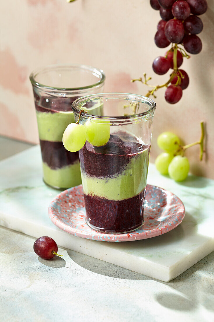 Two-coloured grape smoothie with chokeberry, ginger, sesame and blueberries