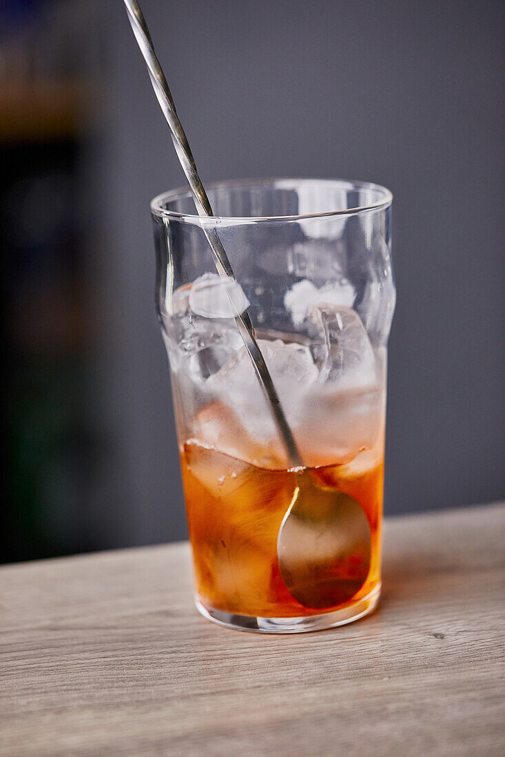 Old Fashioned Cocktail zubereiten: Drink mit Löffel vermischen