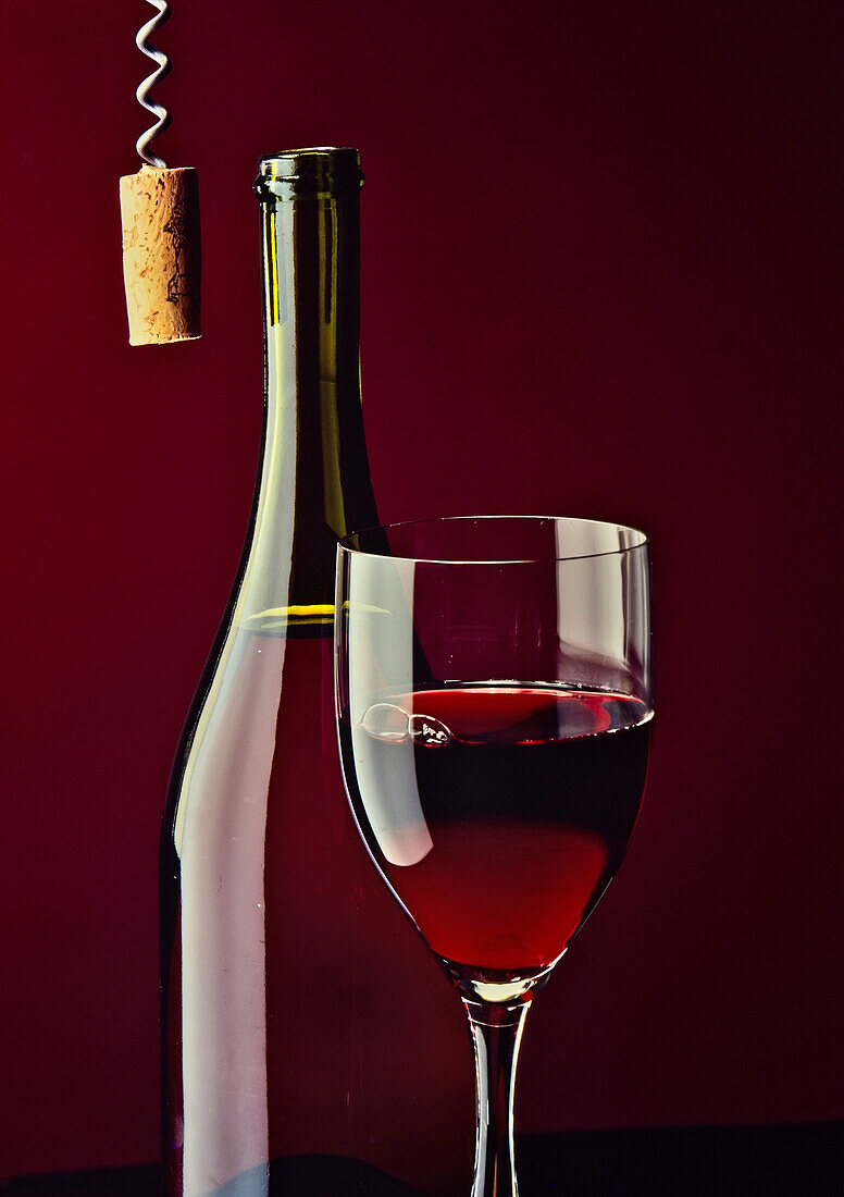 Rotwein im Glas und in der Flasche, mit Korkenzieher