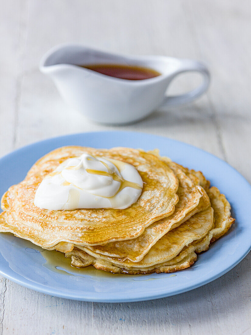 Buttermilk pancakes with whipped cream and maple syrup