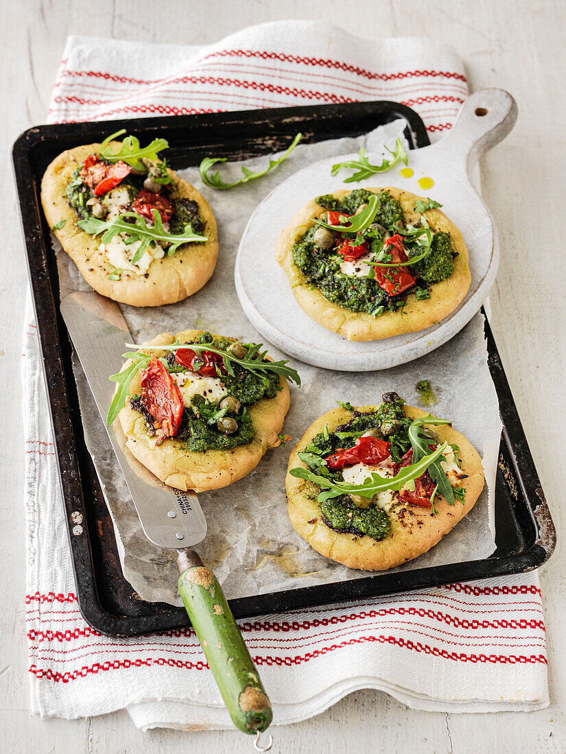 Individual small Pizzas with mozarello, pesto, peppers and rocket