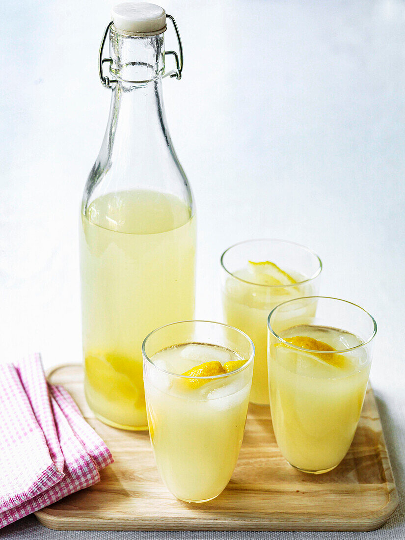 Hausgemachte Zitronenlimonade in Gläsern und Flasche