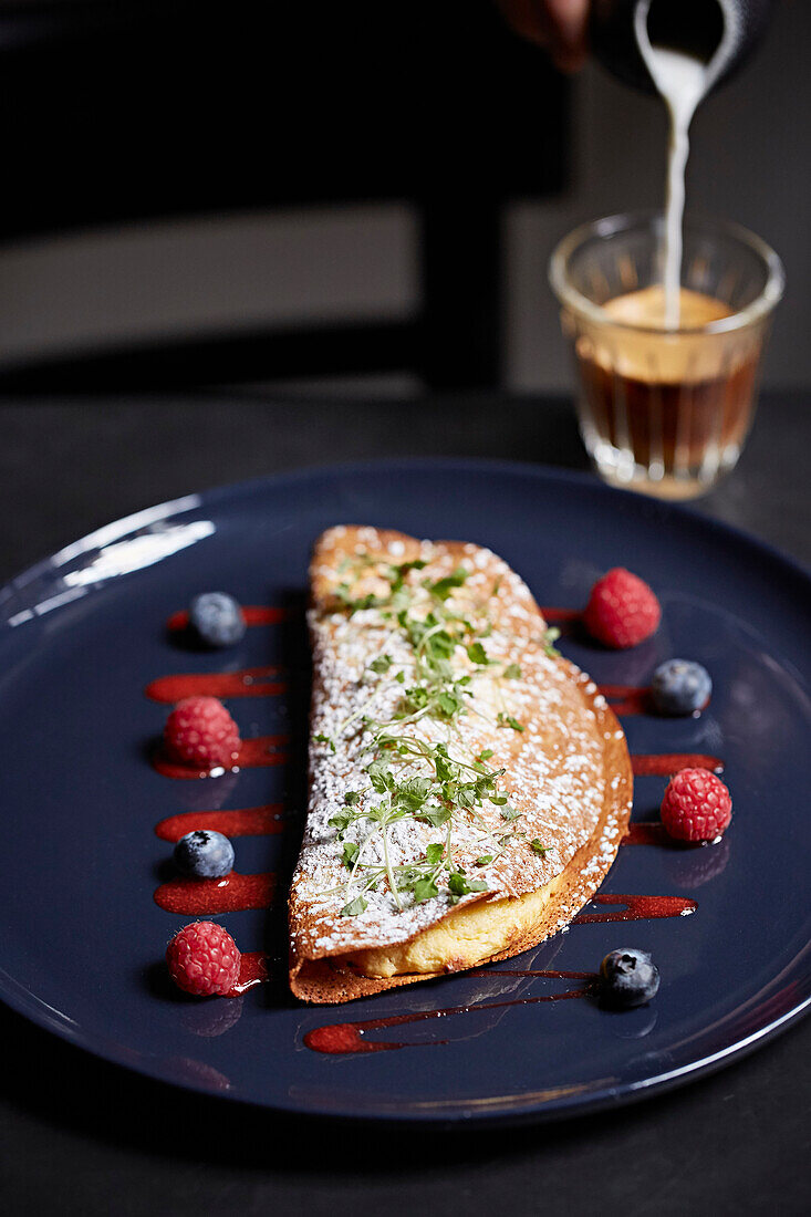 Pancakes filled with pastry cream served with berries and coffee
