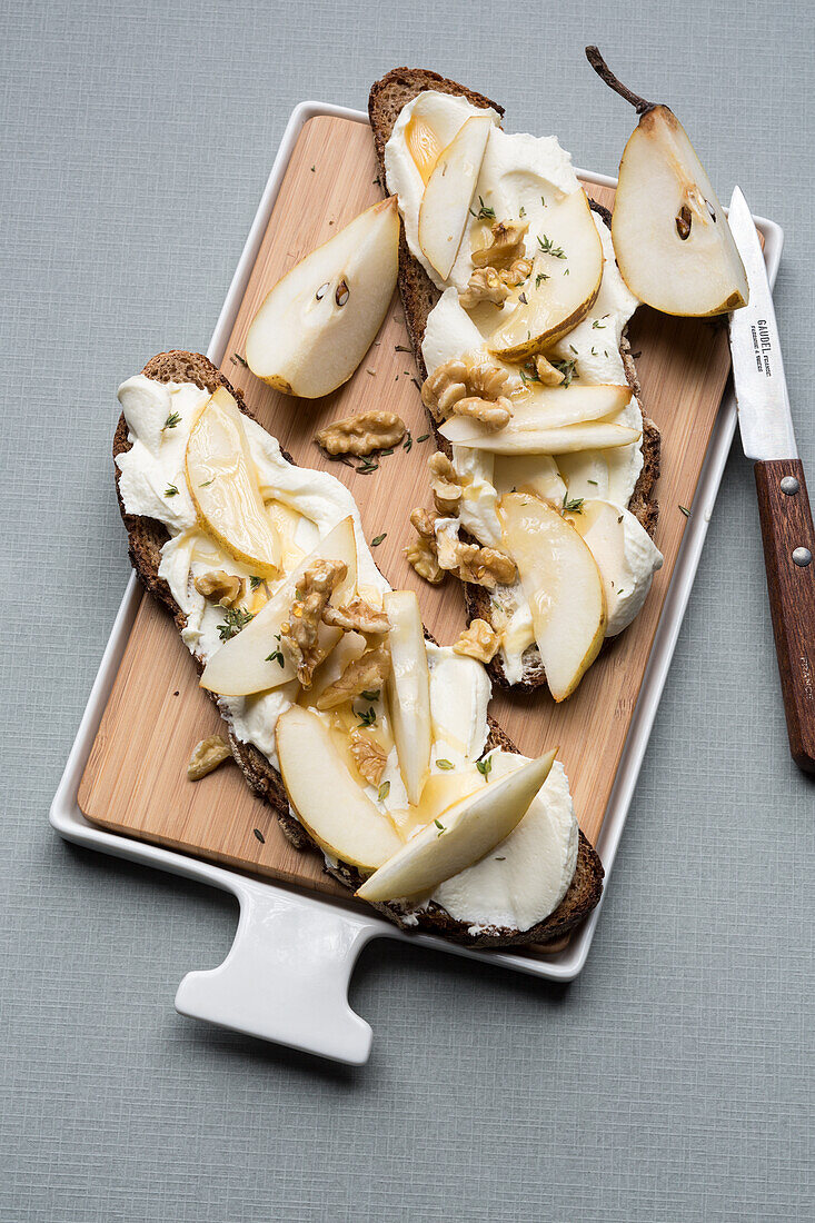 Bread topped with cream cheese, pear and walnuts