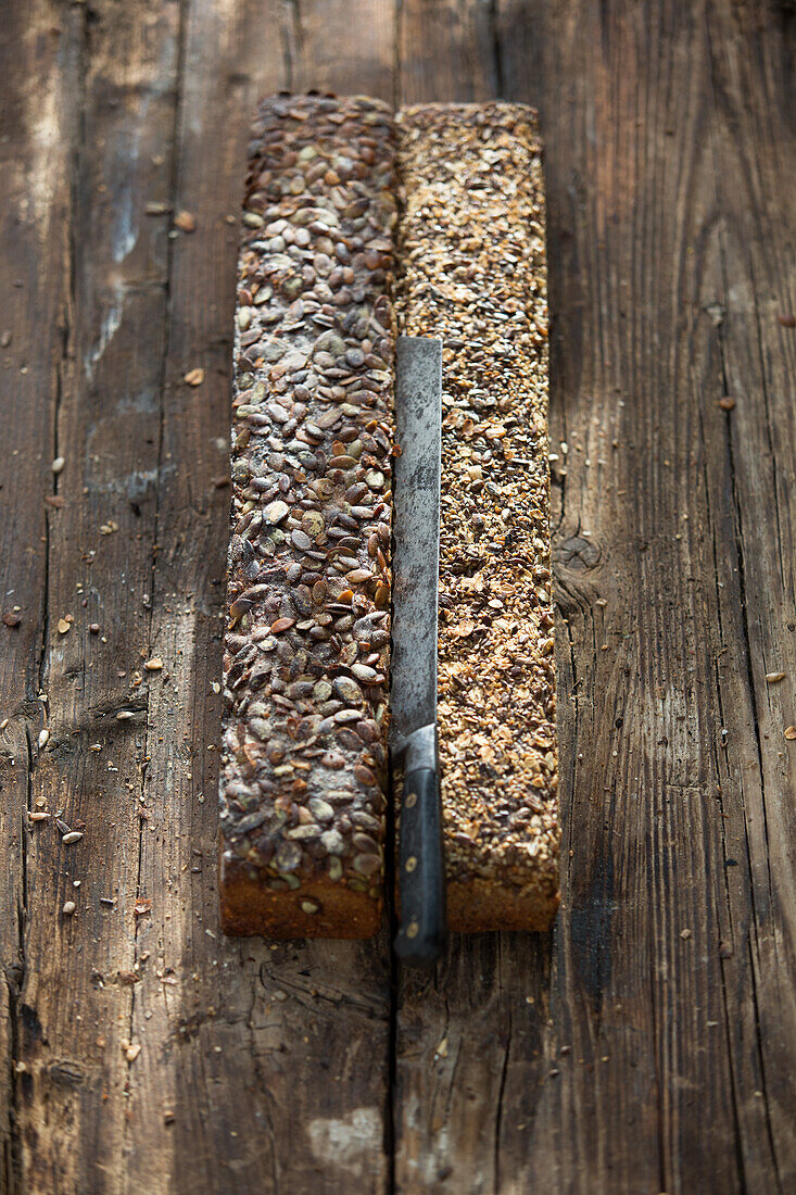 Two loaves with grains and bread knife