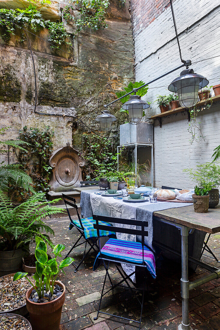 Set table in a leafy courtyard