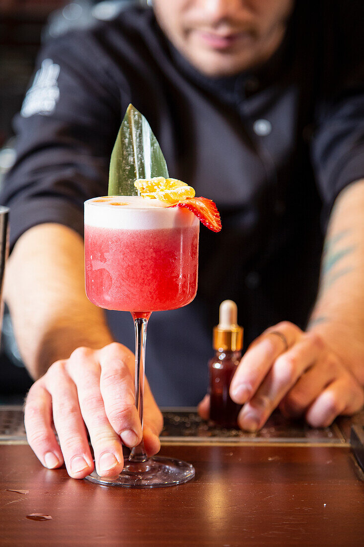 Barkeeper serviert tropischen Cocktail