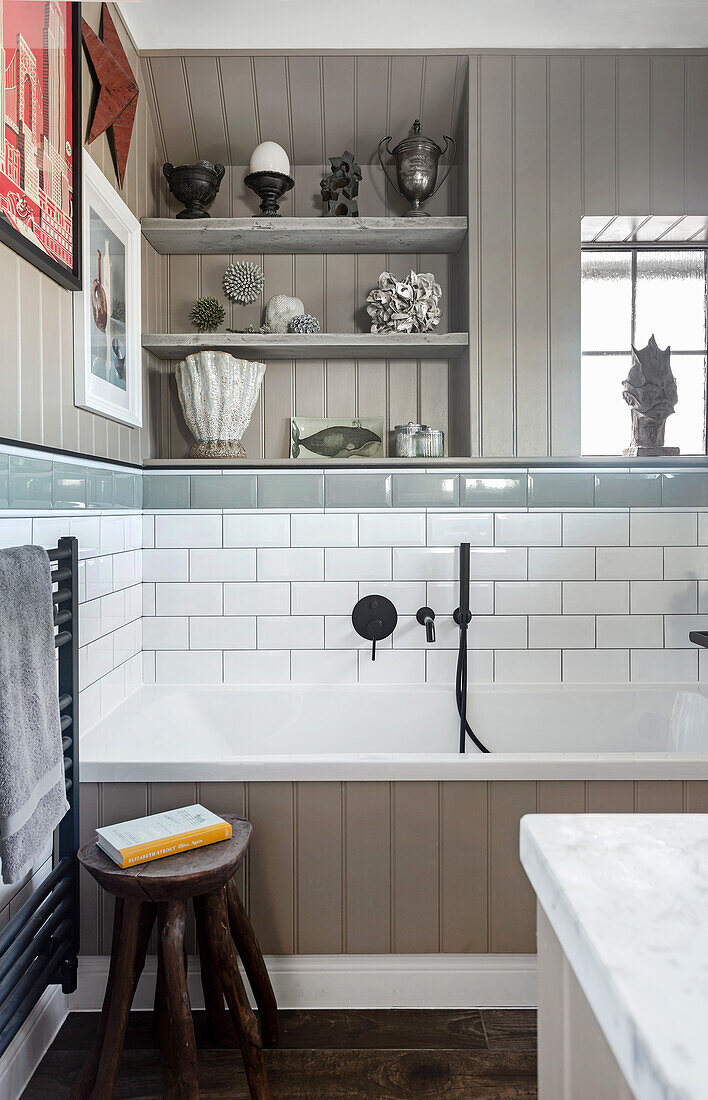 Ceramic collection above the bathtub, wall with tile and with wood paneling