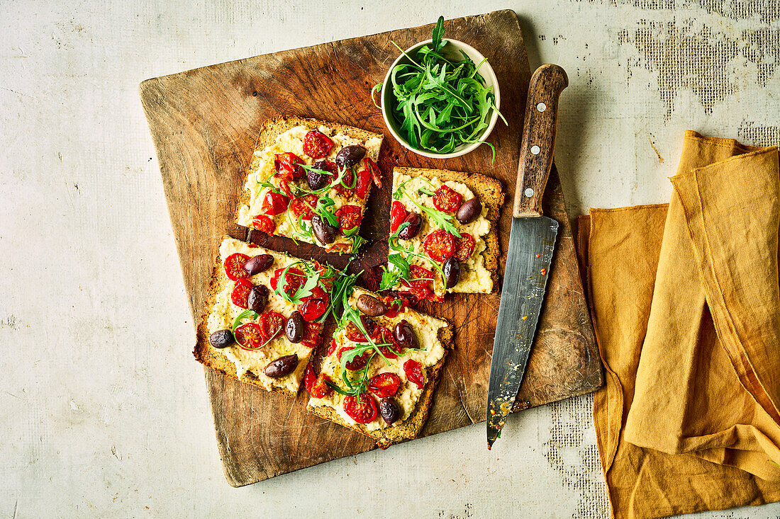 Keto pizza with tomatoes, olives and rocket salad
