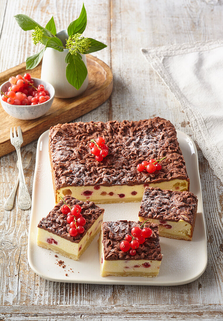Cheesecake on a serving tray with red currants