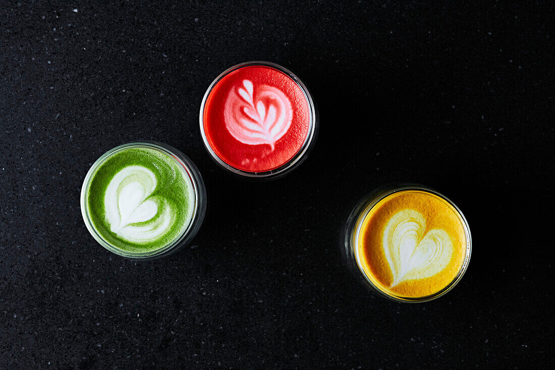 Three colorful healthy smoothies on a dark background