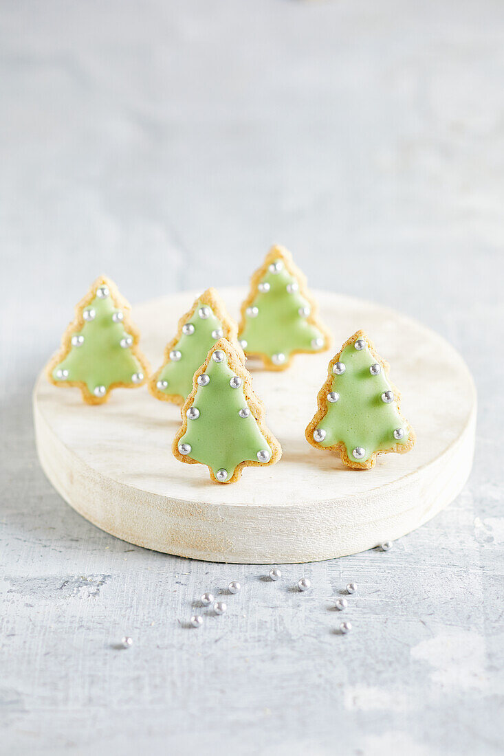 Gebackene Weihnachtsbäume mit grüner Zuckerglasur und Silberperlen