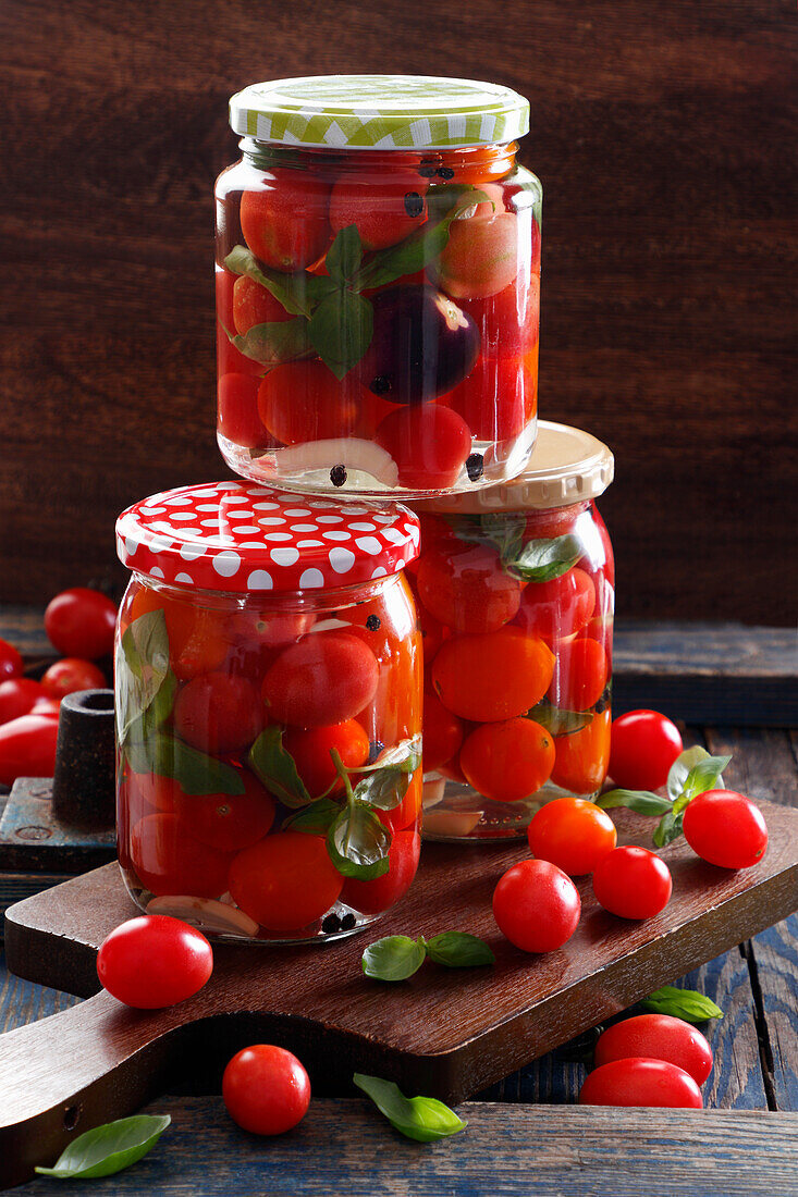 Eingelegte Kirschtomaten mit Basilikum in Schraubgläsern