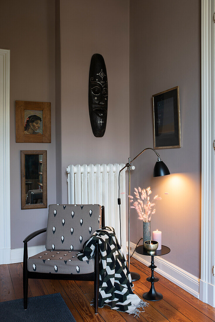 Alter Stuhl mit neuem Bezug in Zimmerecke, Kunstwerke an der Wand
