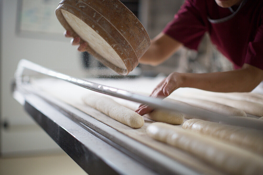 Baguettes wird in Bäckerei mit Mehl bestäubt