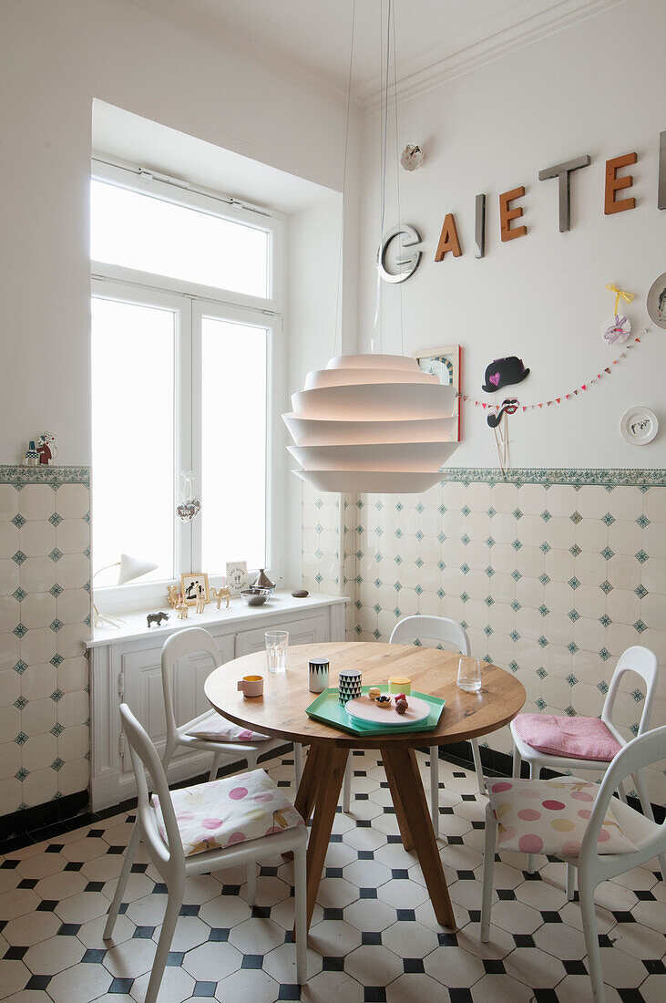 Breakfast table with minimalist chairs in tiled kitchen