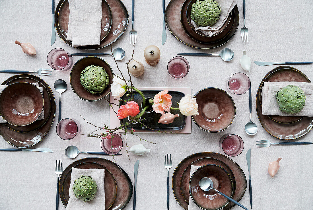Gedeckter Tisch mit Mohnblüten und Artischocken dekoriert