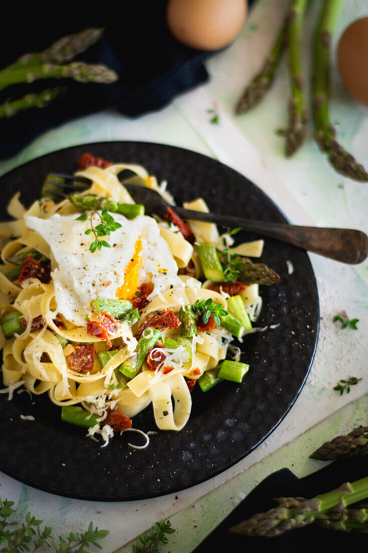 Tagliatelle with green asparagus, sun-dried tomatoes, and poached egg